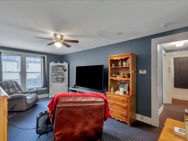 living room with ceiling fan and dark carpet