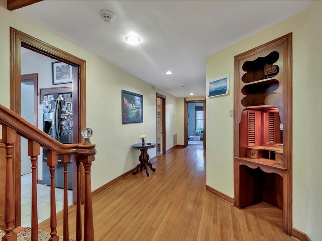 corridor with light hardwood / wood-style floors