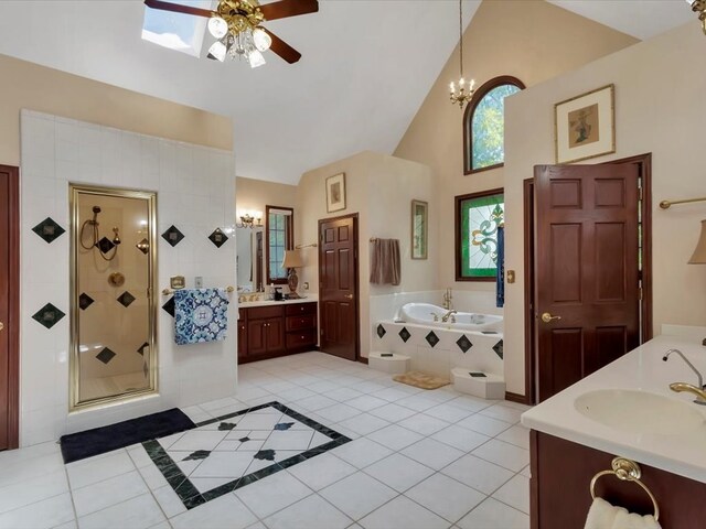 bathroom featuring tile patterned floors, a skylight, separate shower and tub, and vanity