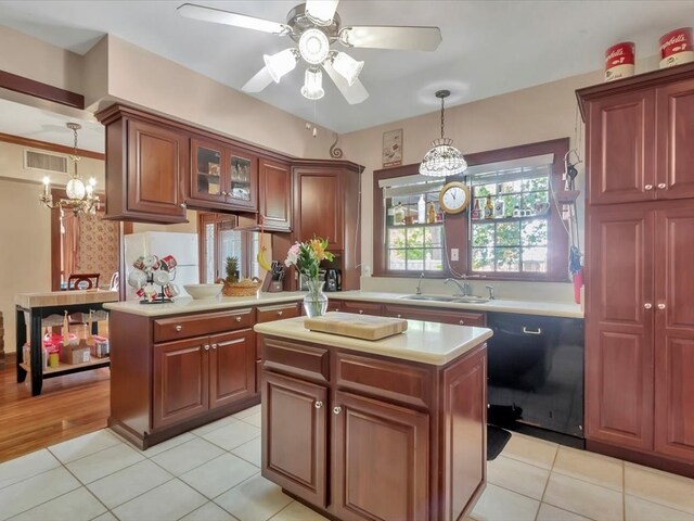 kitchen with black dishwasher, a center island, decorative light fixtures, and sink