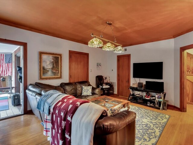 living room with ornamental molding and light wood-type flooring