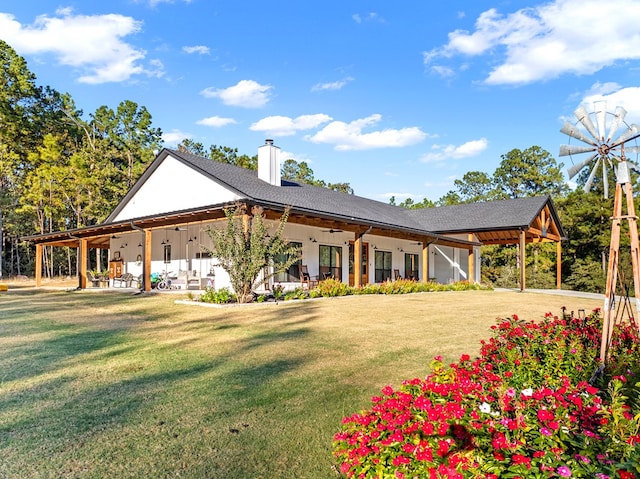 back of property with a lawn and ceiling fan