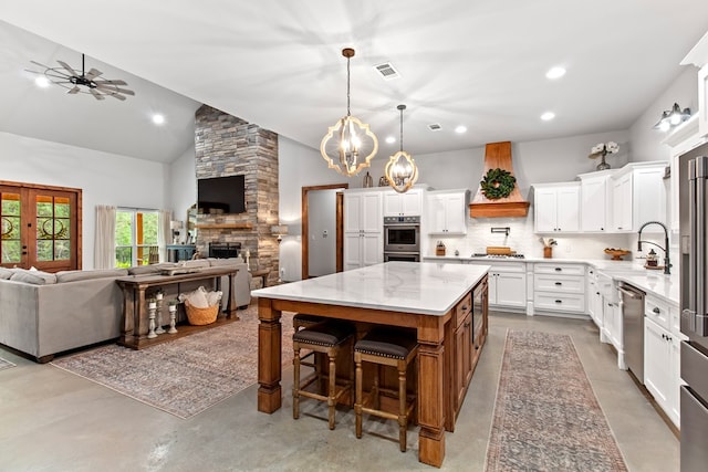 kitchen with white cabinetry, a center island, light stone counters, concrete floors, and custom exhaust hood