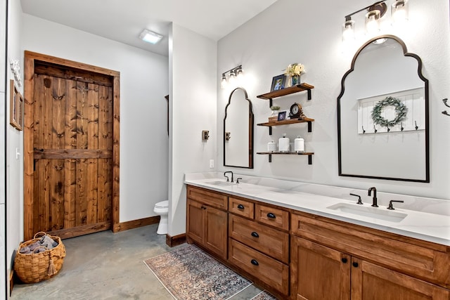 bathroom featuring vanity, concrete floors, and toilet