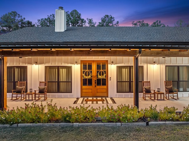 back house at dusk featuring french doors