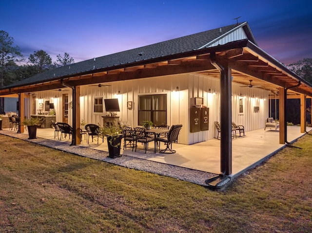 back of property featuring a lawn, ceiling fan, a fireplace, and a patio