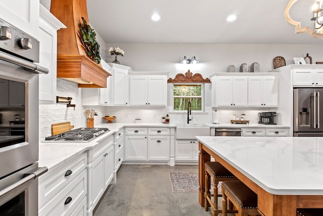 kitchen with light stone countertops, sink, tasteful backsplash, white cabinets, and appliances with stainless steel finishes