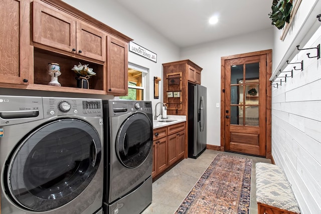 washroom featuring cabinets, independent washer and dryer, and sink