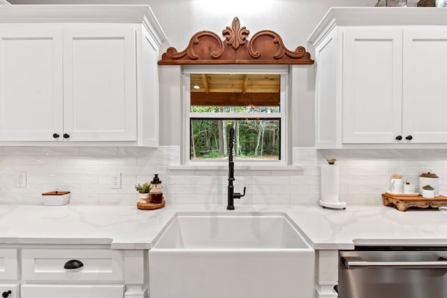 kitchen featuring stainless steel dishwasher, white cabinets, and sink