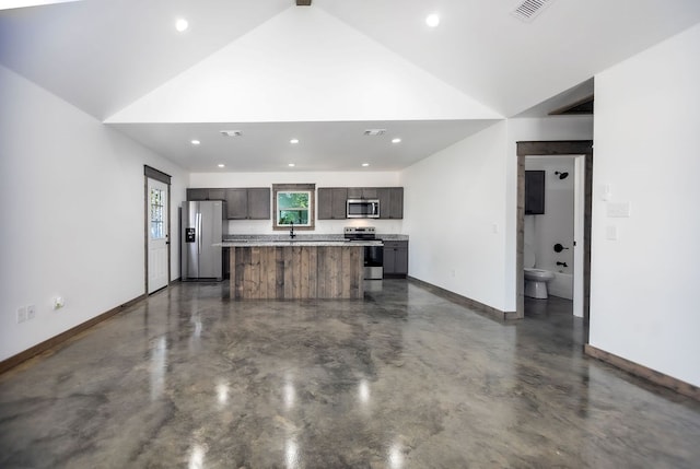 kitchen featuring sink, a center island, vaulted ceiling, and appliances with stainless steel finishes