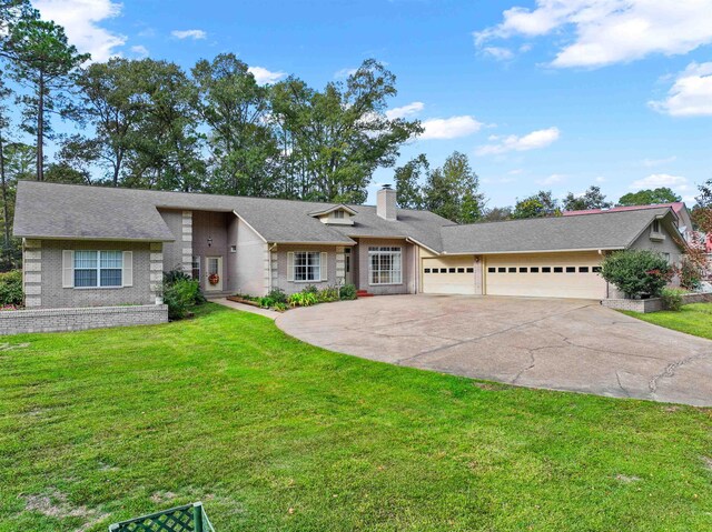 827 Duffer Dr, Brookeland, TX 75931 - view of front of home with an attached garage, a chimney, driveway, a front yard, and roof with shingles