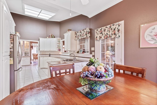 tiled dining space featuring ornamental molding and sink