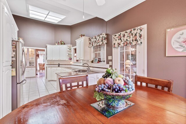 tiled dining space featuring ornamental molding and sink