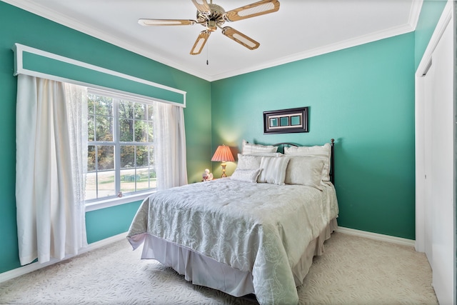 bedroom with ceiling fan, crown molding, light carpet, and a closet