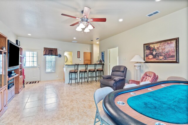 tiled living room with ceiling fan