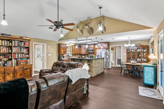 living room featuring plenty of natural light, ceiling fan with notable chandelier, dark wood-type flooring, and lofted ceiling