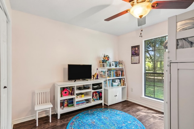 game room with dark hardwood / wood-style flooring, ceiling fan, and a healthy amount of sunlight