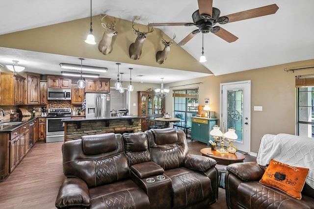 living room with ceiling fan with notable chandelier, sink, high vaulted ceiling, and light hardwood / wood-style flooring