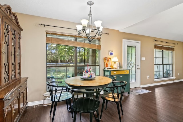 dining area with dark wood-type flooring and a notable chandelier