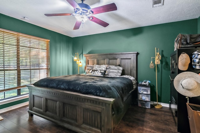 bedroom featuring ceiling fan, dark hardwood / wood-style flooring, and a textured ceiling