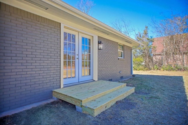 entrance to property with crawl space, french doors, and brick siding