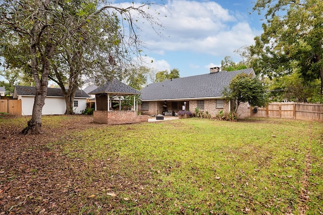 rear view of property featuring a gazebo, a patio area, and a lawn