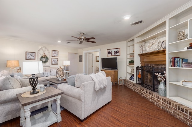 living room featuring built in shelves, ceiling fan, a fireplace, and dark wood-type flooring