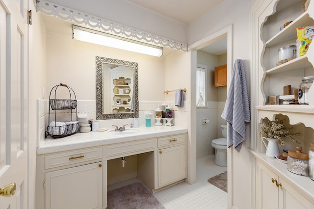 bathroom with tile patterned floors, vanity, tile walls, and toilet