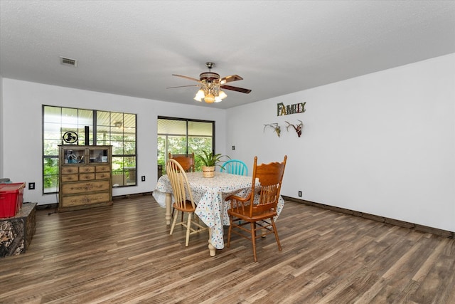 dining area featuring a textured ceiling, ceiling fan, and dark hardwood / wood-style floors