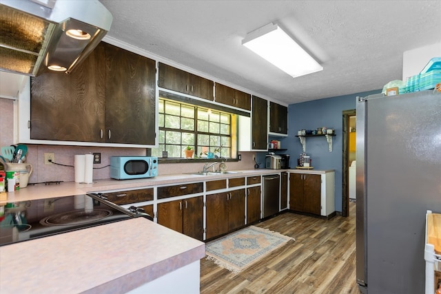 kitchen featuring appliances with stainless steel finishes, a textured ceiling, dark brown cabinets, and sink