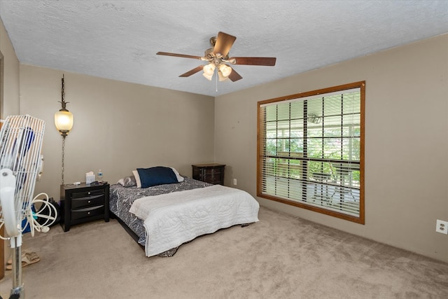 bedroom with light carpet, a textured ceiling, and ceiling fan