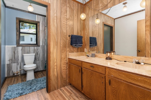 bathroom featuring vanity, wood-type flooring, tile walls, toilet, and wood walls