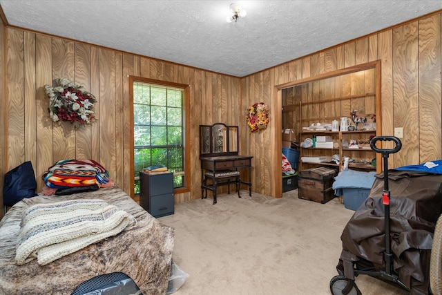 bedroom featuring light carpet and wooden walls