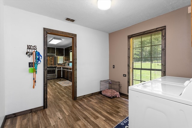 laundry area featuring a textured ceiling, separate washer and dryer, and dark hardwood / wood-style floors