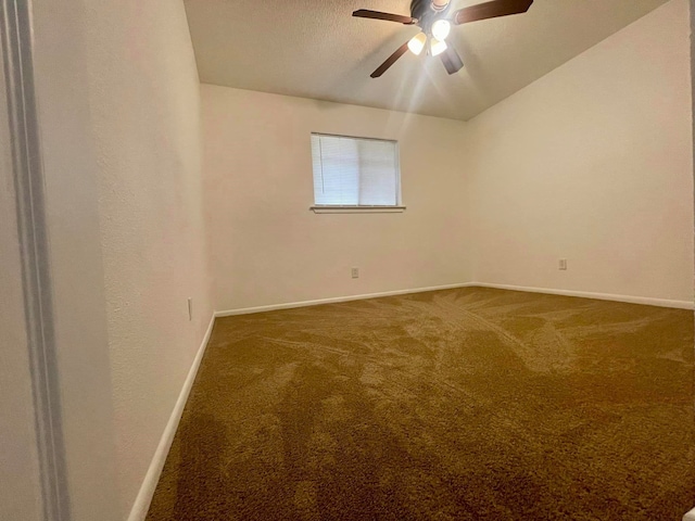 carpeted spare room with a textured ceiling, vaulted ceiling, and ceiling fan