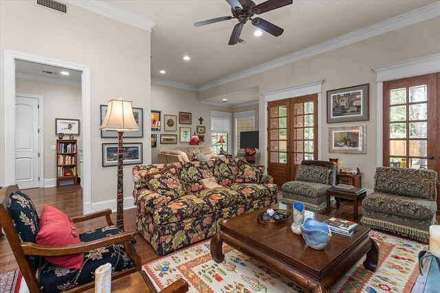 living room with french doors, crown molding, dark hardwood / wood-style floors, ceiling fan, and built in features