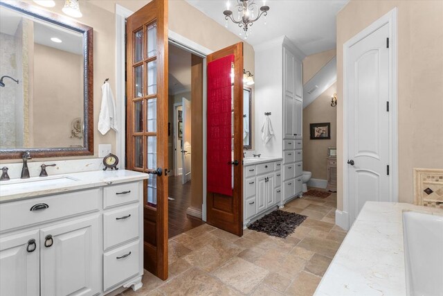 bathroom featuring a chandelier, vanity, and a bathtub