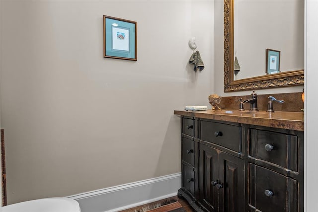 bathroom with vanity, toilet, and wood-type flooring