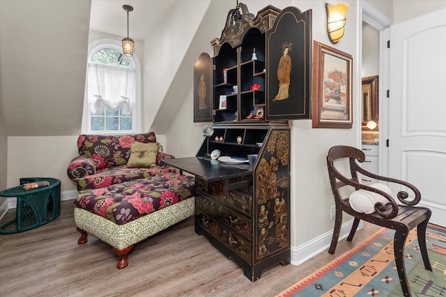 living area featuring vaulted ceiling and light hardwood / wood-style flooring