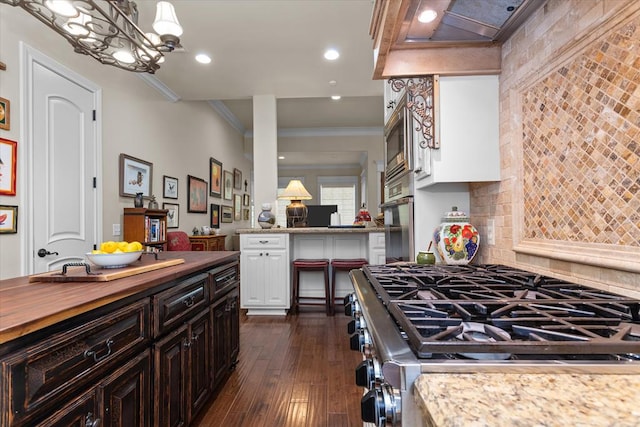 kitchen featuring dark brown cabinetry, stainless steel appliances, crown molding, butcher block countertops, and dark hardwood / wood-style floors