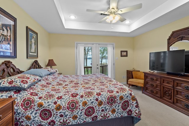 bedroom featuring light carpet, french doors, access to outside, a raised ceiling, and ceiling fan