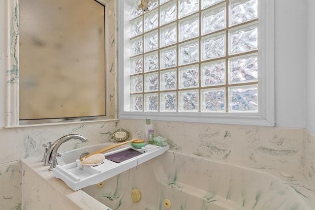 bathroom featuring a relaxing tiled tub and a wealth of natural light