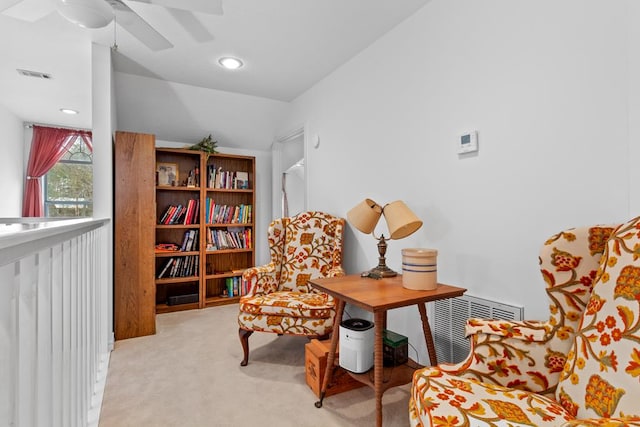 sitting room featuring light carpet, ceiling fan, and vaulted ceiling