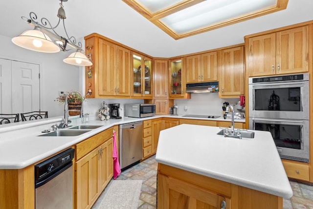 kitchen with stainless steel appliances, a center island with sink, hanging light fixtures, and sink