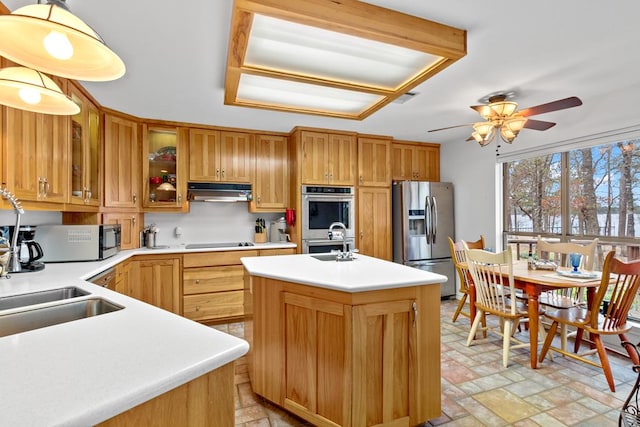 kitchen with ceiling fan, a kitchen island with sink, appliances with stainless steel finishes, and sink