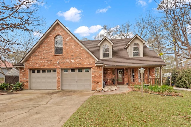 view of front of property featuring a front lawn, a garage, and a porch