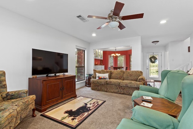 living room with ceiling fan with notable chandelier and light carpet