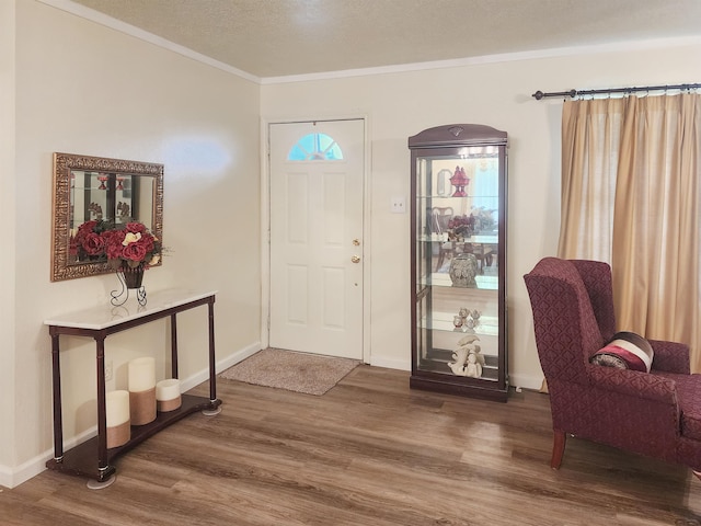 foyer entrance featuring crown molding, a textured ceiling, and hardwood / wood-style flooring