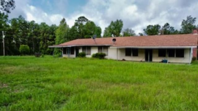 rear view of property with a yard