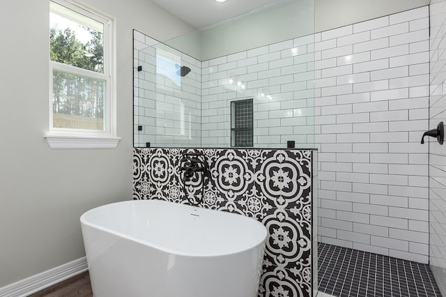 full bathroom featuring wood finished floors, a freestanding tub, baseboards, and walk in shower